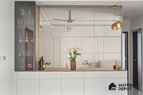 Modern bar unit with frosty white laminate, glass display, and mirrored wall panels of 2 BHK in Purva Palm Beach Hennur Bengaluru | Material Depot