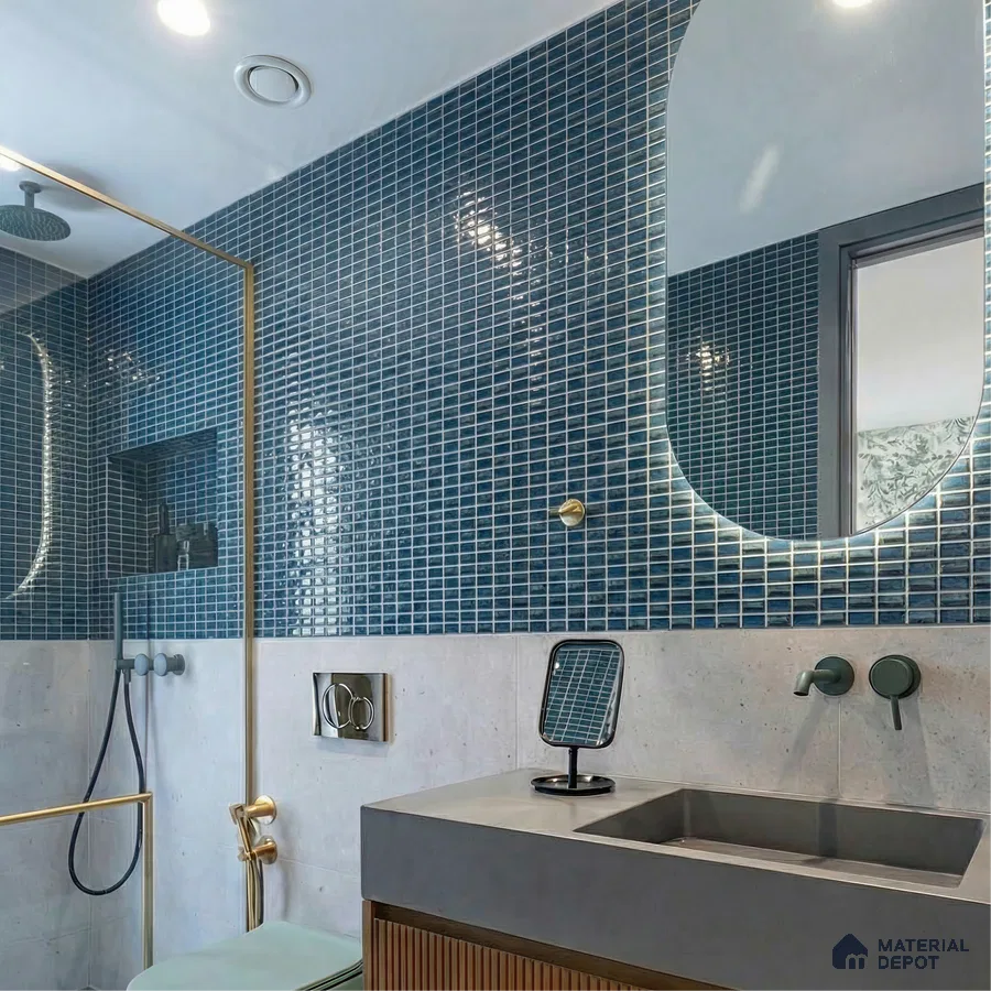 Modern bathroom with blue mosaic wall tiles, concrete countertop, and fluted wood vanity