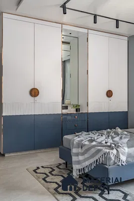 Modern bedroom with dual-tone white and blue laminate wardrobe and geometric rug | Material Depot