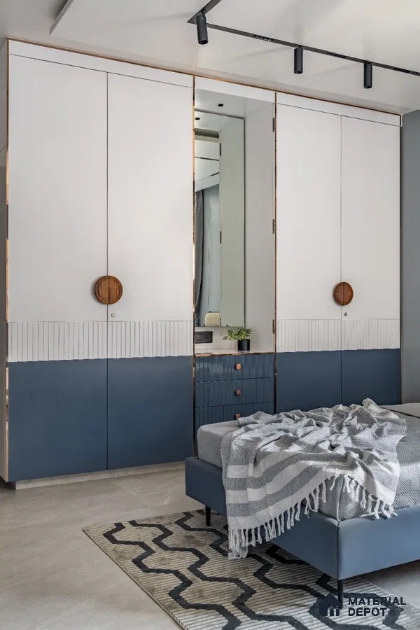 Modern bedroom with dual-tone white and blue laminate wardrobe and geometric rug | Material Depot
