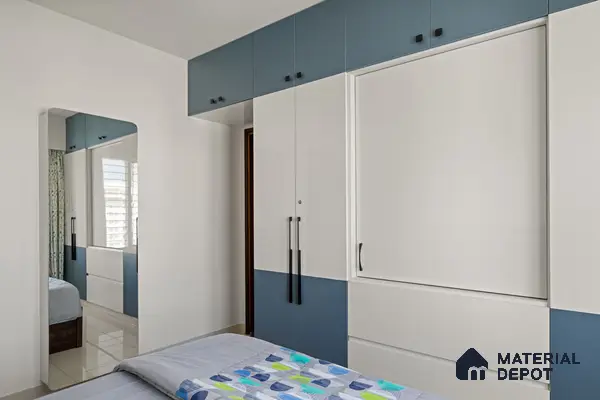 Modern bedroom with dual-tone blue and white laminate wardrobe and glossy tile flooring of 2 BHK in Purva Palm Beach Hennur Bengaluru | Material Depot