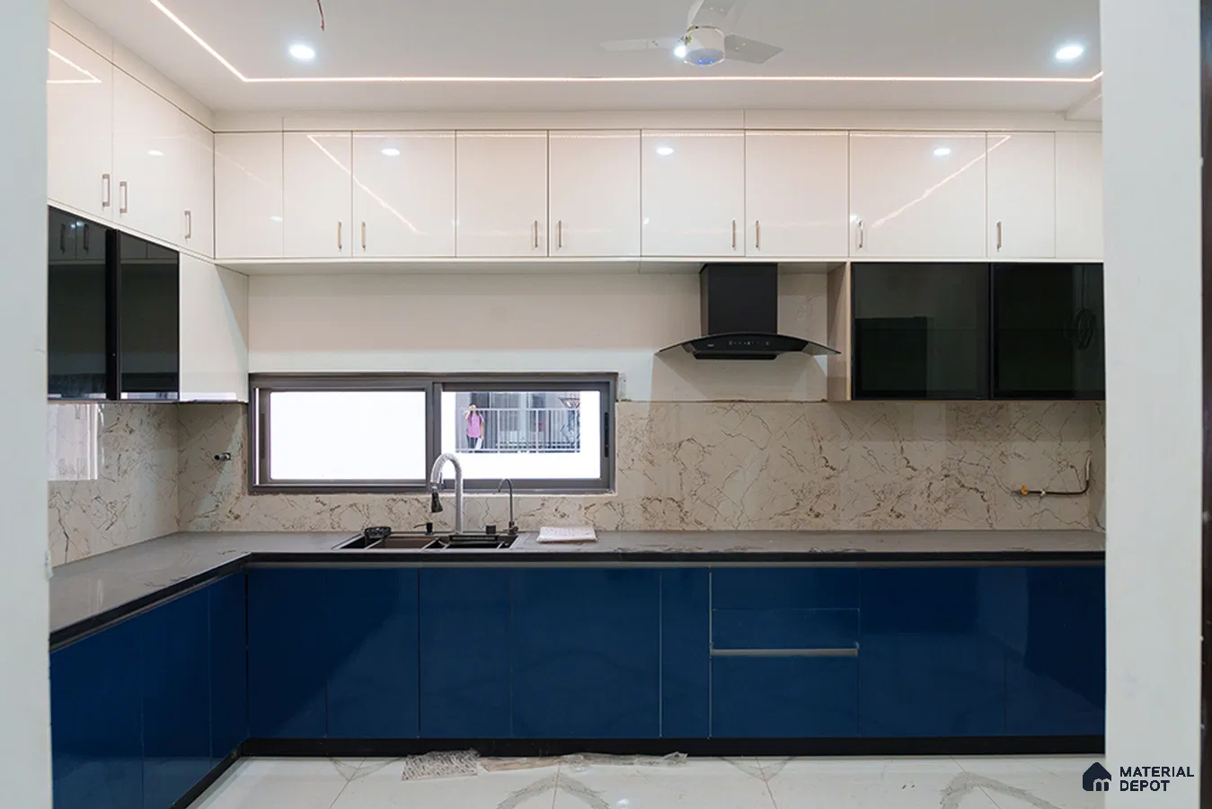 Modern dual tone kitchen with blue and white high gloss laminate, marble-look backsplash, and grey quartz countertop in Bengaluru | Material Depot