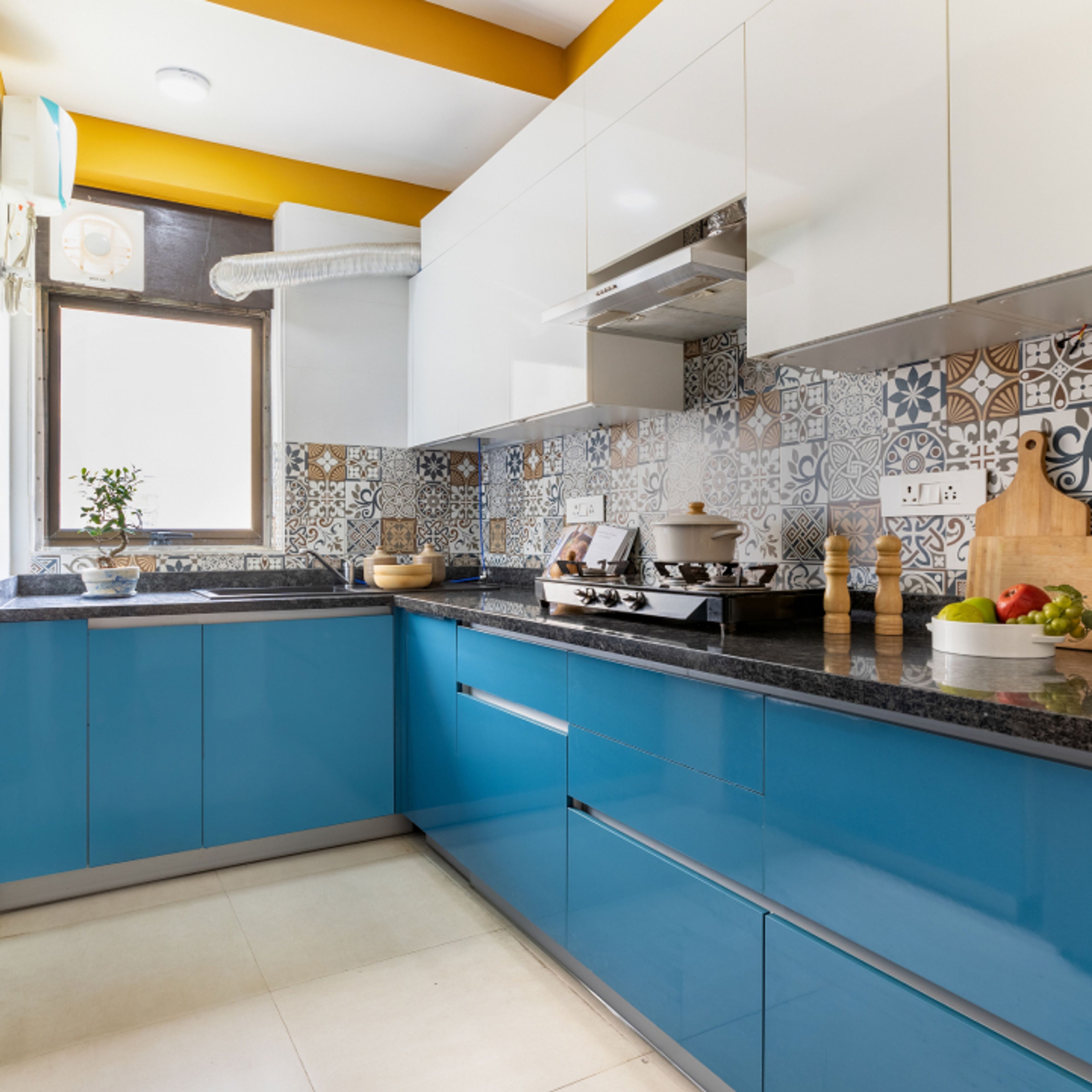 Modern dual tone kitchen with blue high gloss laminate, white laminate, and patterned moroccan backsplash tiles in Bengaluru | Material Depot