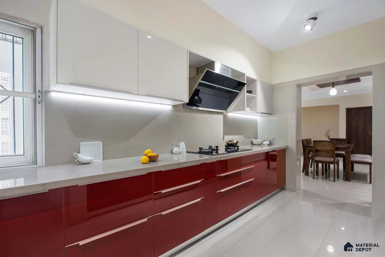 Modern dual tone kitchen with high gloss red and frosty white laminate, quartz countertop, and beige floor tile in Bengaluru | Material Depot