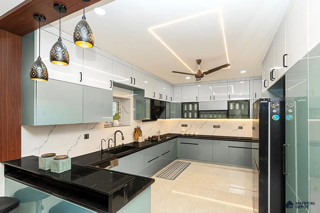 Modern dual tone kitchen with pastel blue and frosty white high gloss laminate, black granite countertop, and marble-look backsplash in Bengaluru | Material Depot