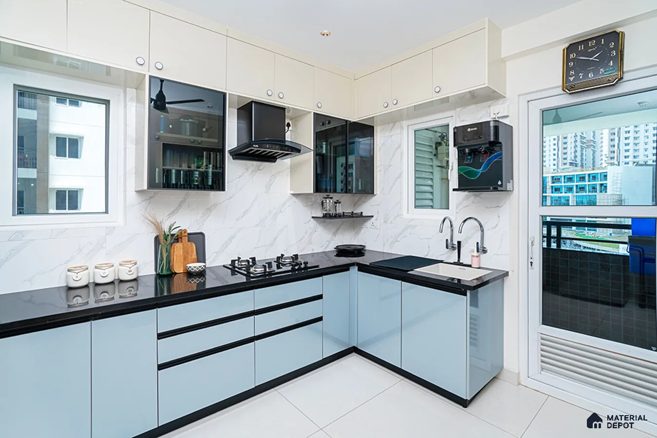 Modern dual tone kitchen with pastel blue and frosty white high gloss laminate, black quartz countertop, and marble-look backsplash tile in Bengaluru | Material Depot