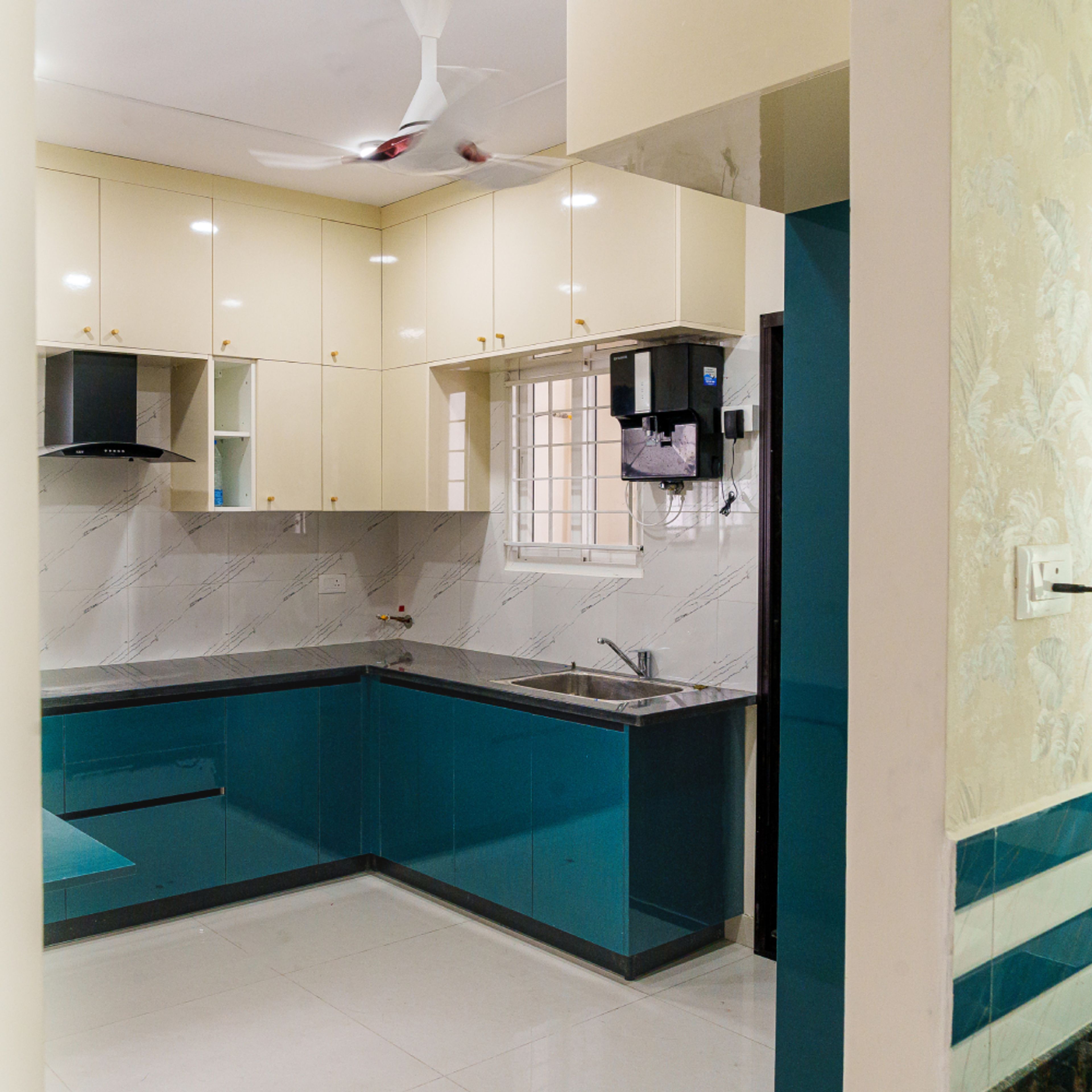 Modern dual tone kitchen with teal blue and cream high gloss laminate, marble look backsplash tile, and white floor tile in Bengaluru | Material Depot