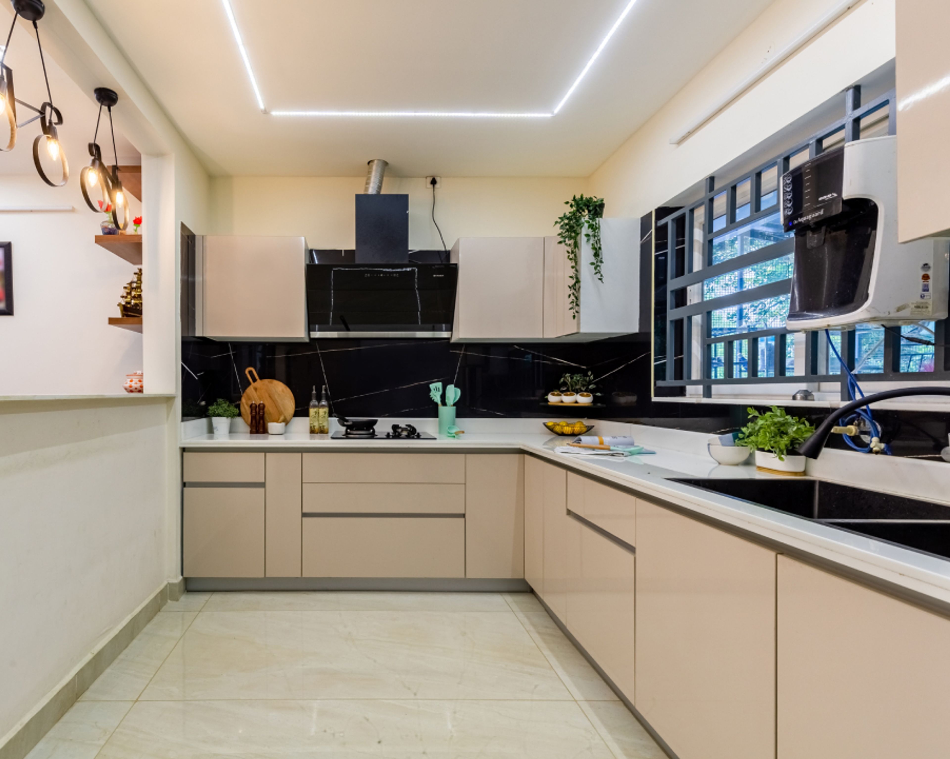Modern kitchen with beige high gloss laminate cabinets, black marble-look backsplash, and white quartz countertop in Bengaluru | Material Depot