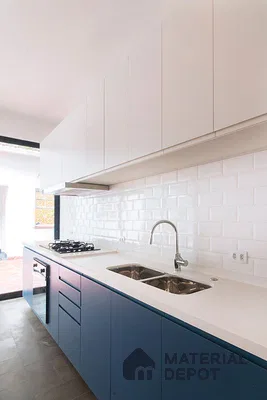 Modern kitchen with blue laminate base cabinets, white laminate wall cabinets, and white subway tile backsplash in Bengaluru | Material Depot