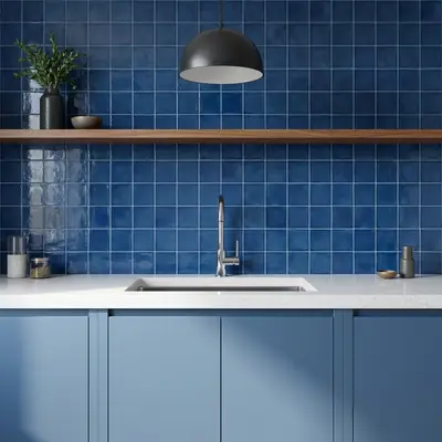 Modern kitchen with blue square wall tiles, pastel blue laminate cabinets, and white quartz countertop
