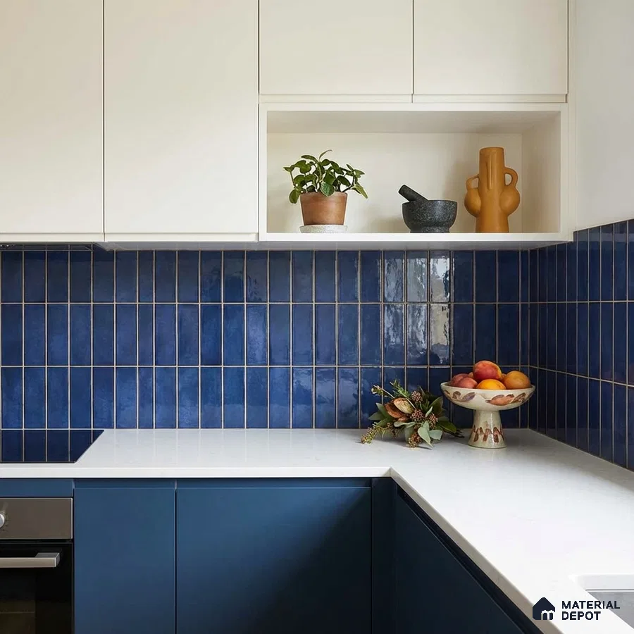 Modern kitchen with blue vertical subway backsplash tile, white quartz countertop, and dual tone laminate cabinets