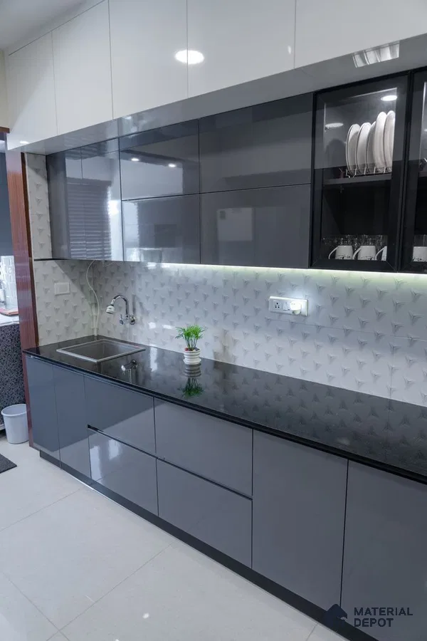 Modern kitchen with glossy grey and white laminate cabinets, black granite countertop, and 3D geometric white backsplash tile in Bengaluru | Material Depot