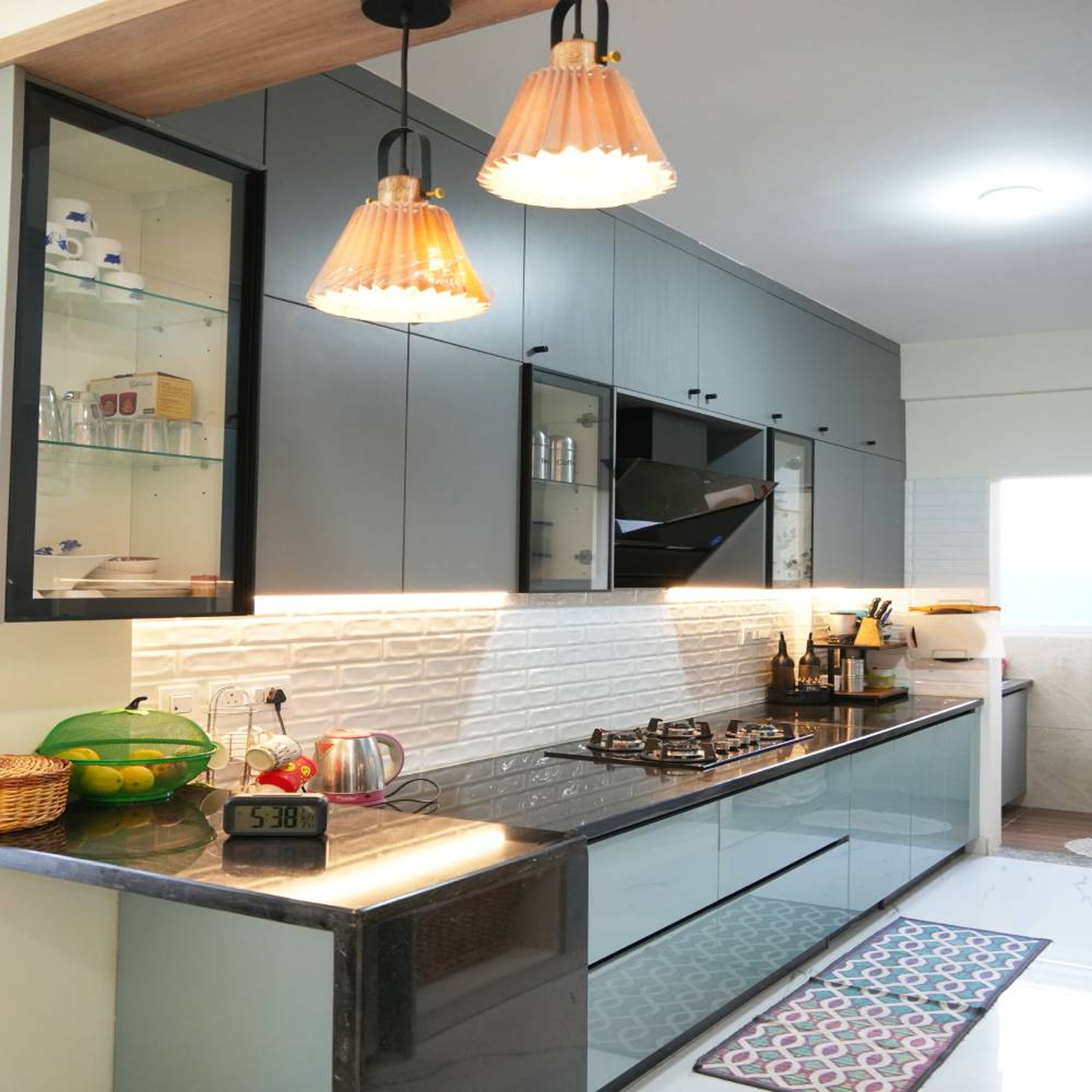 Modern kitchen with grey matte laminate cabinets, black granite countertop, and white 3D subway backsplash tiles in Bengaluru | Material Depot