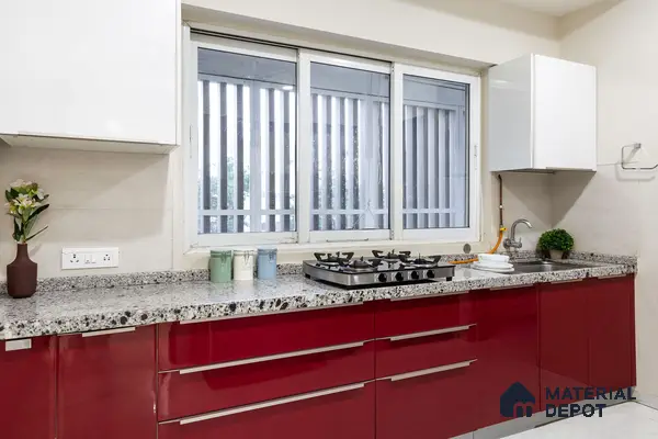 Modern kitchen with high gloss red laminate cabinets and speckled granite countertop in Bengaluru | Material Depot