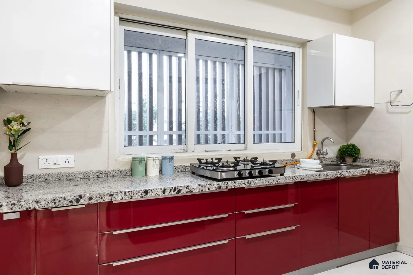 Modern kitchen with high gloss red laminate cabinets and speckled granite countertop in Bengaluru | Material Depot