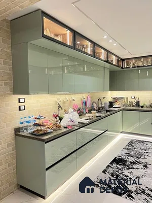 Modern kitchen with sage green high gloss laminate cabinets, brick look wall tiles, and black granite countertop in Bengaluru | Material Depot