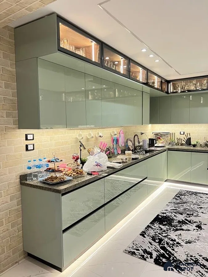 Modern kitchen with sage green high gloss laminate cabinets, brick look wall tiles, and black granite countertop in Bengaluru | Material Depot