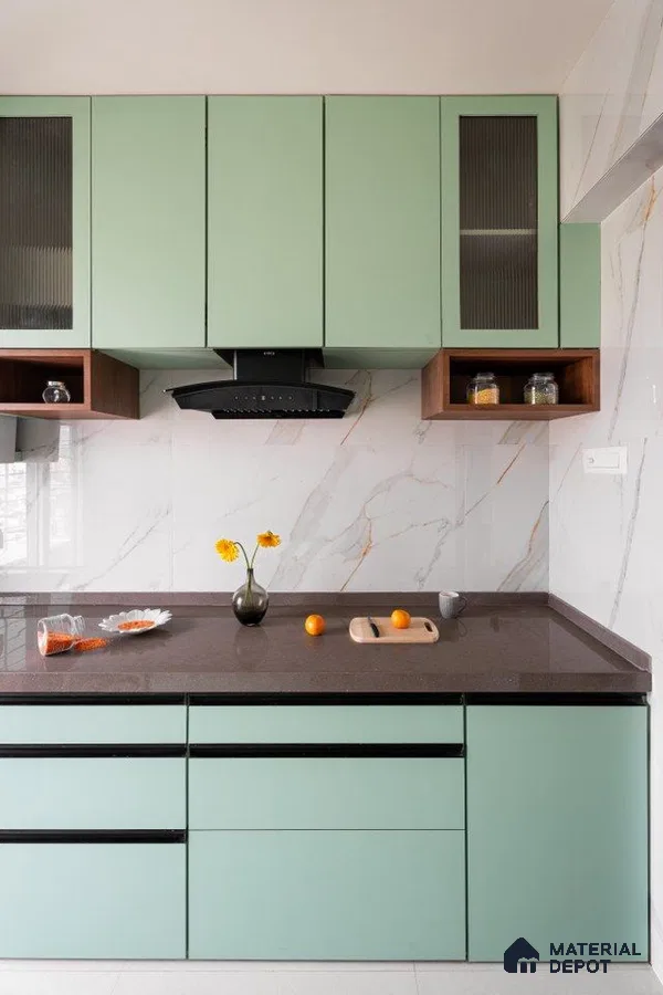 Modern kitchen with sage green laminate cabinets, brown quartz countertop, and marble-look wall tiles in Bengaluru | Material Depot