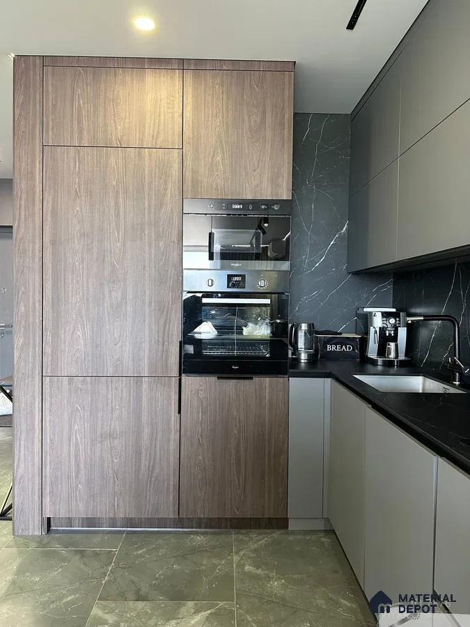 Modern kitchen with walnut wood laminate, matte grey laminate, and black marble backsplash in Bengaluru | Material Depot