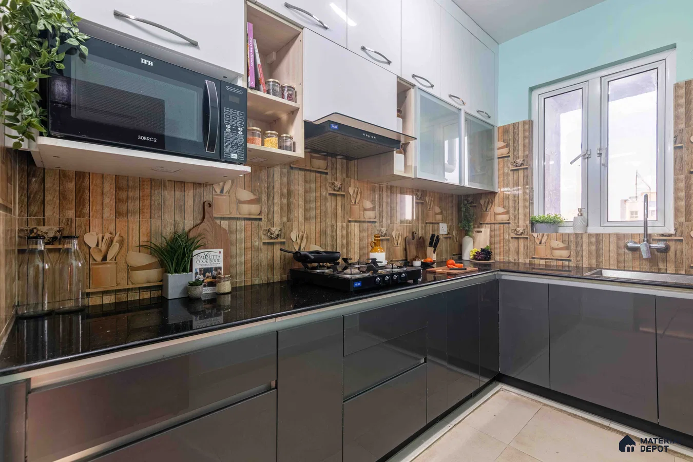 Modern L-shaped kitchen with glossy grey and frosty white laminate, black granite countertop, and wood-look patterned backsplash tile in Bengaluru | Material Depot