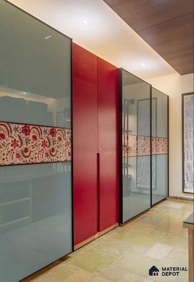 Modern wardrobe with frosty blue glass shutters, red solid color laminate, and floral patterned panel | Material Depot