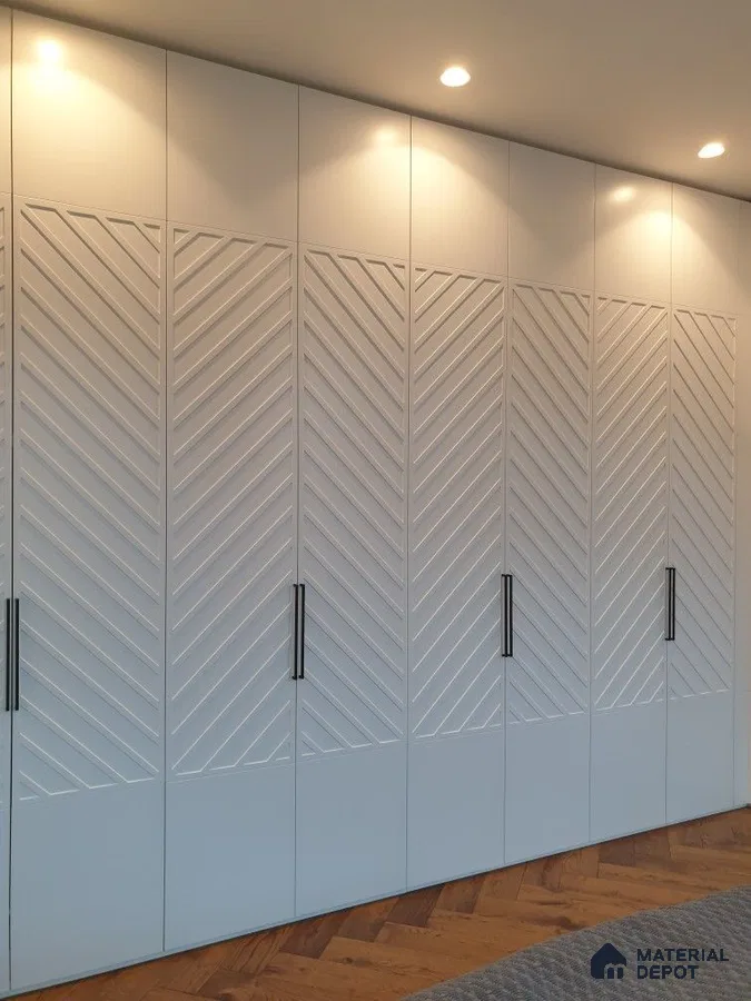 Modern wardrobe with frosty white chevron patterned laminate shutters and herringbone wooden flooring | Material Depot