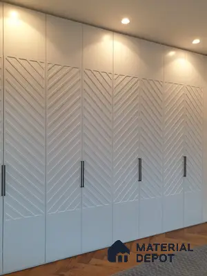 Modern wardrobe with frosty white chevron patterned laminate shutters and herringbone wooden flooring | Material Depot