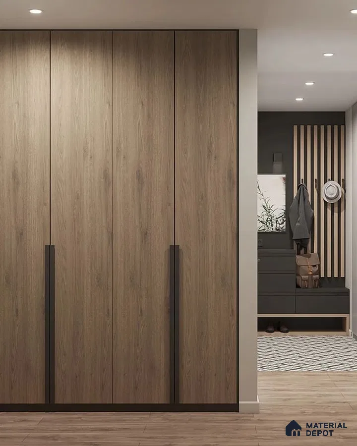 Modern wardrobe with oak wood laminate shutters and black accent handles in entryway | Material Depot