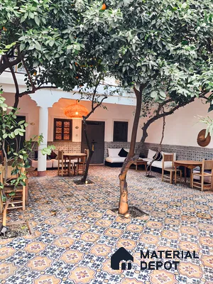 Moroccan-Inspired Courtyard with Patterned Tiles and Orange Tree | Material Depot