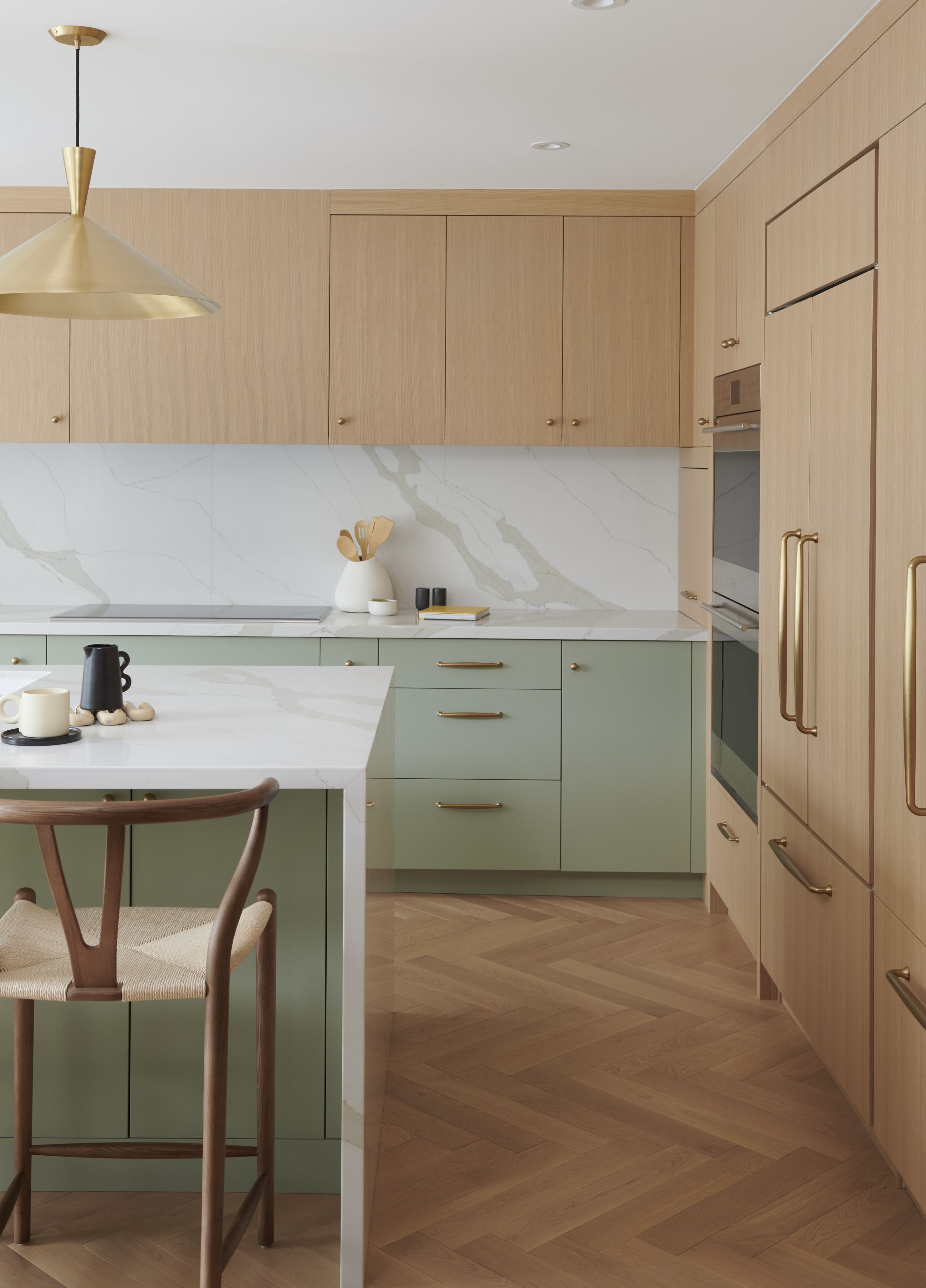 Scandinavian kitchen with light oak laminate, sage green laminate, and white marble-look backsplash in Bengaluru | Material Depot