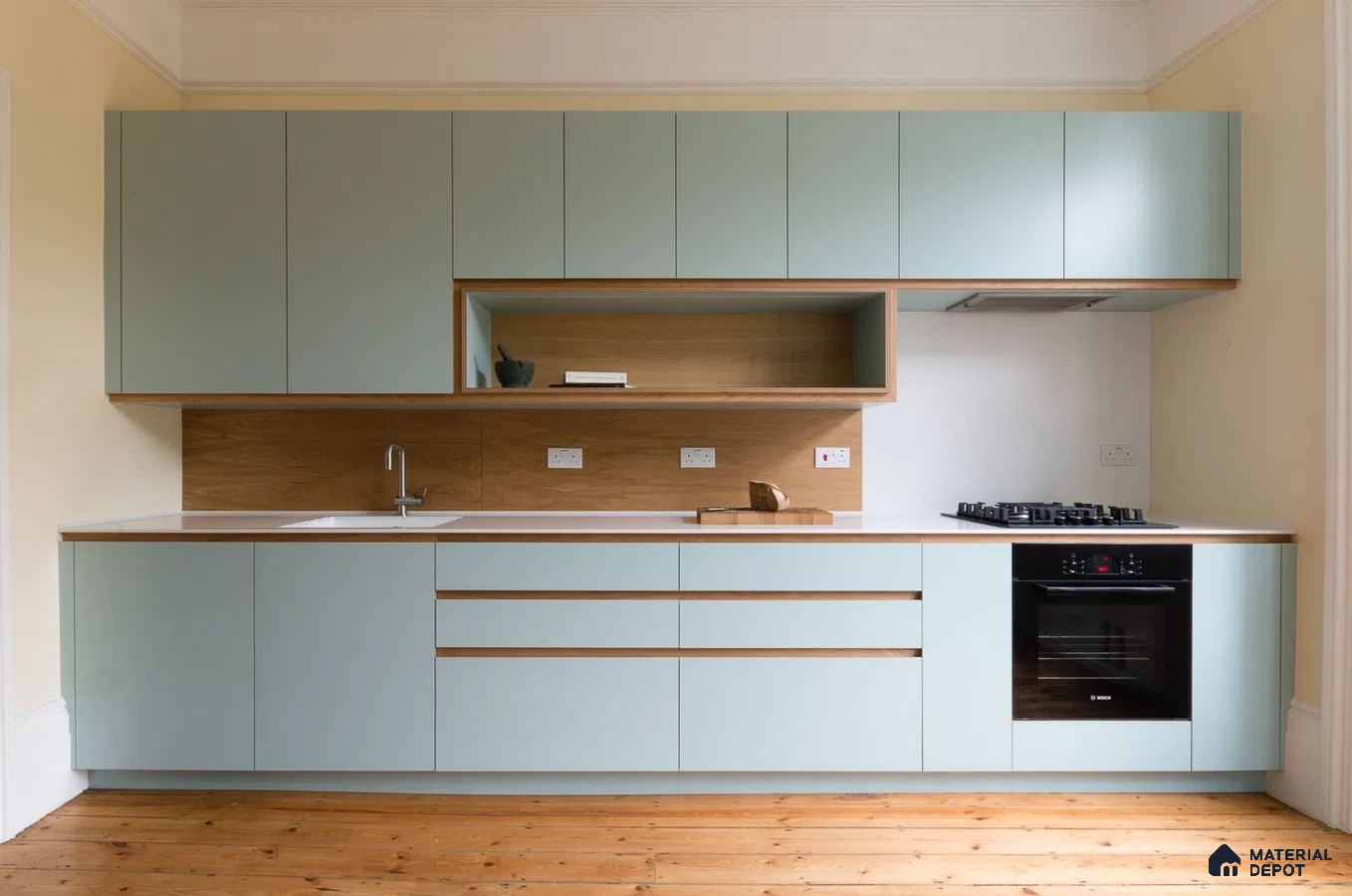 Scandinavian kitchen with pastel green laminate, natural oak laminate backsplash, and white countertop in Bengaluru | Material Depot