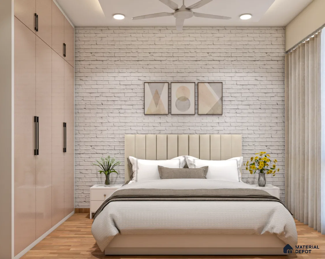 simple and stylish bedroom with a white brick wall, three framed artworks, a bed, a plant, and a flower vase