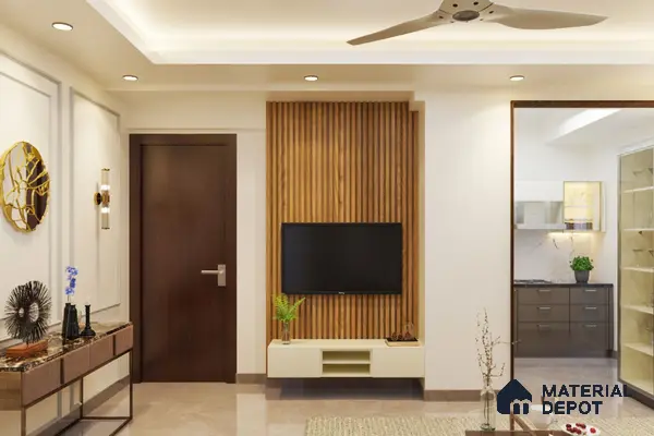 Room with a wooden wall and a gold mirror, a wooden console table with blue vases and a potted plant, a ceiling fan and a flat-screen TV
