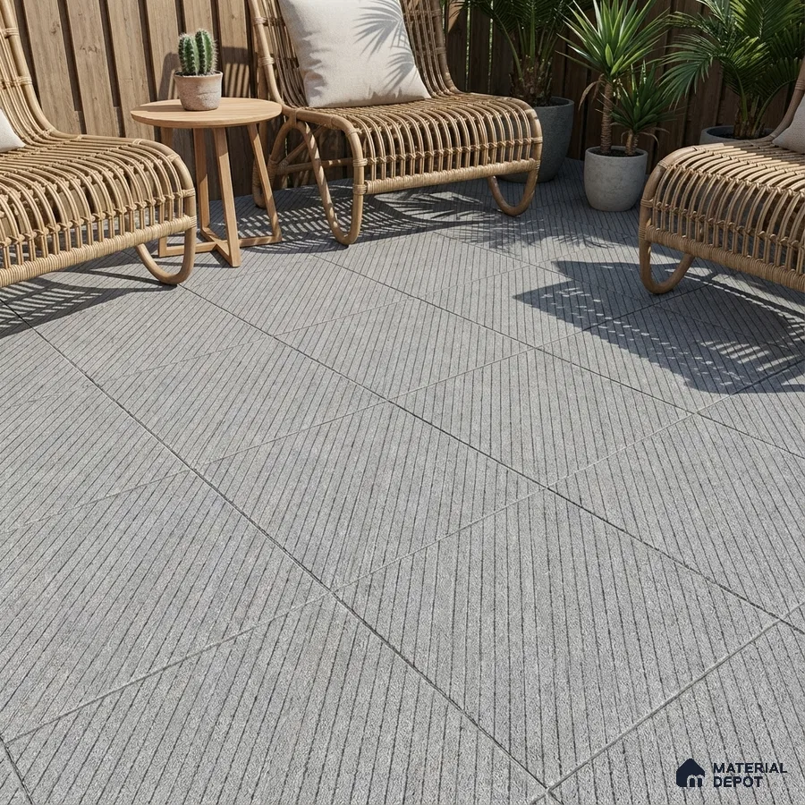 Scandinavian outdoor space with grey textured floor tiles and rattan furniture