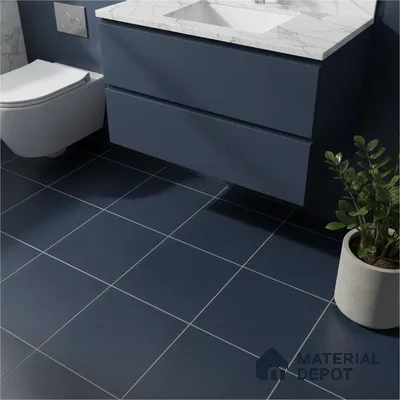 Modern bathroom with navy blue floor tiles, matte blue vanity laminate, and white marble countertop