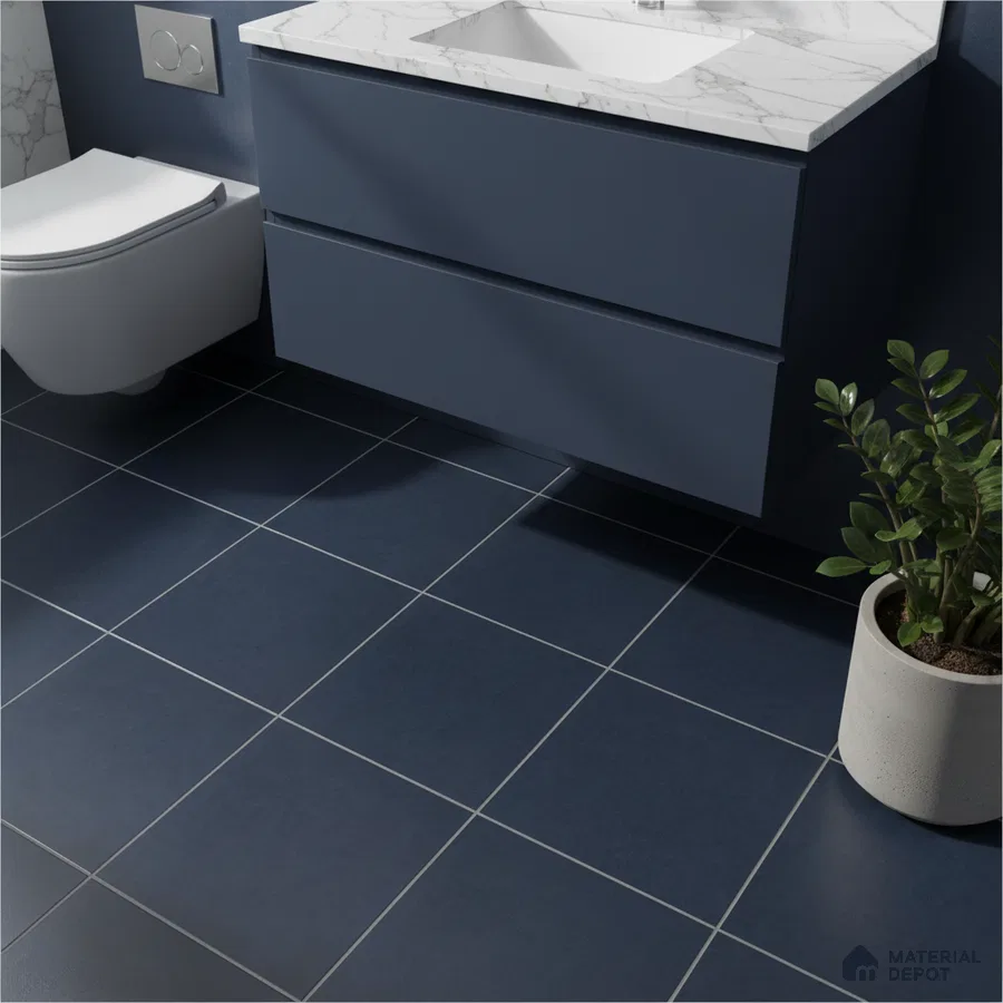 Modern bathroom with navy blue floor tiles, matte blue vanity laminate, and white marble countertop