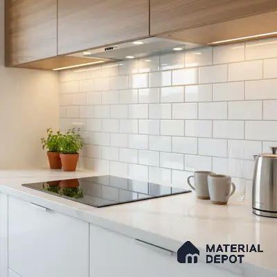 Modern kitchen with white quartz countertop, white subway backsplash tile, and light oak laminate cabinets