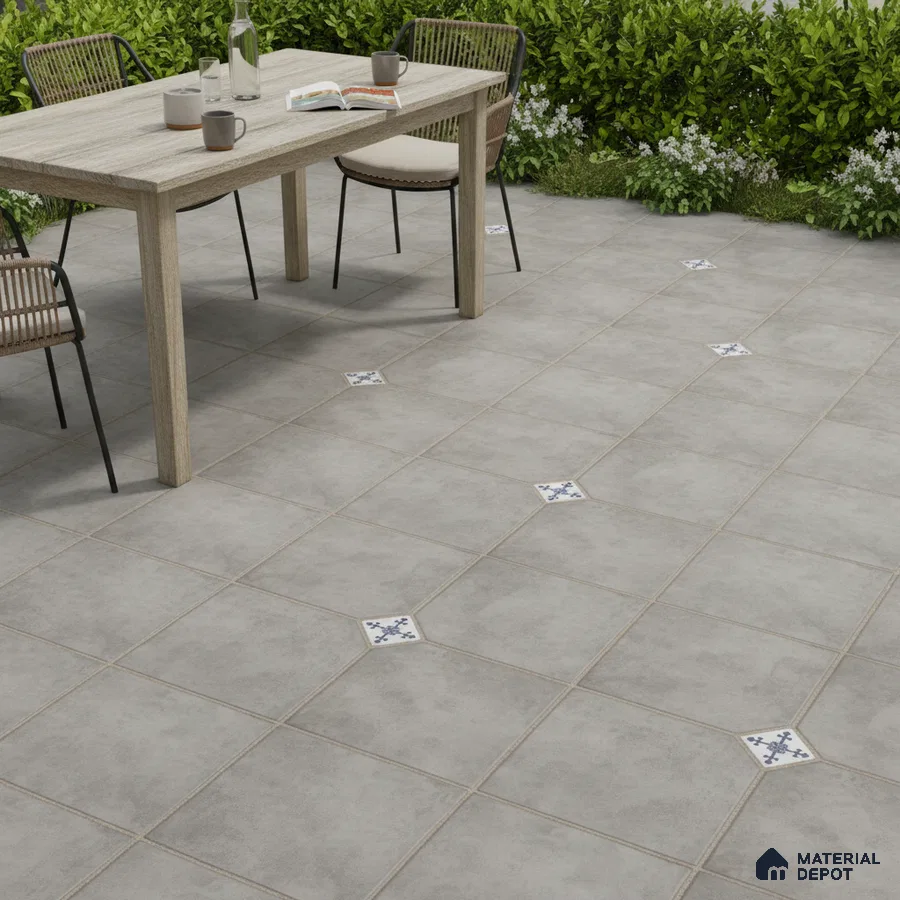 Minimalist outdoor space with grey stone-look floor tiles and blue patterned accent inserts