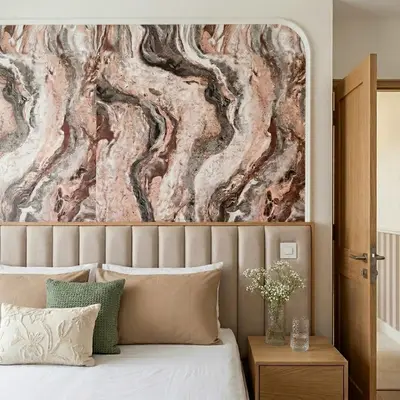 Modern bedroom with marble-effect wallpaper accent wall and suede upholstered headboard