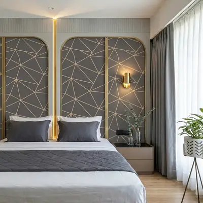 Modern bedroom with geometric gold-accent wall panels and grey upholstery