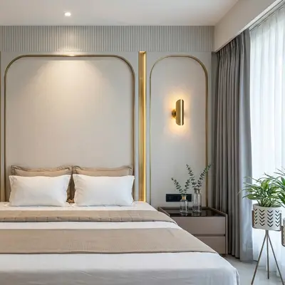 Modern bedroom with beige fabric wall panels, gold accent trims, and neutral palette