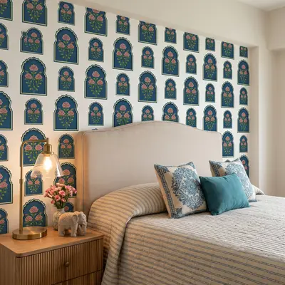 Eclectic bedroom with Indian floral patterned wallpaper and beige upholstered bed